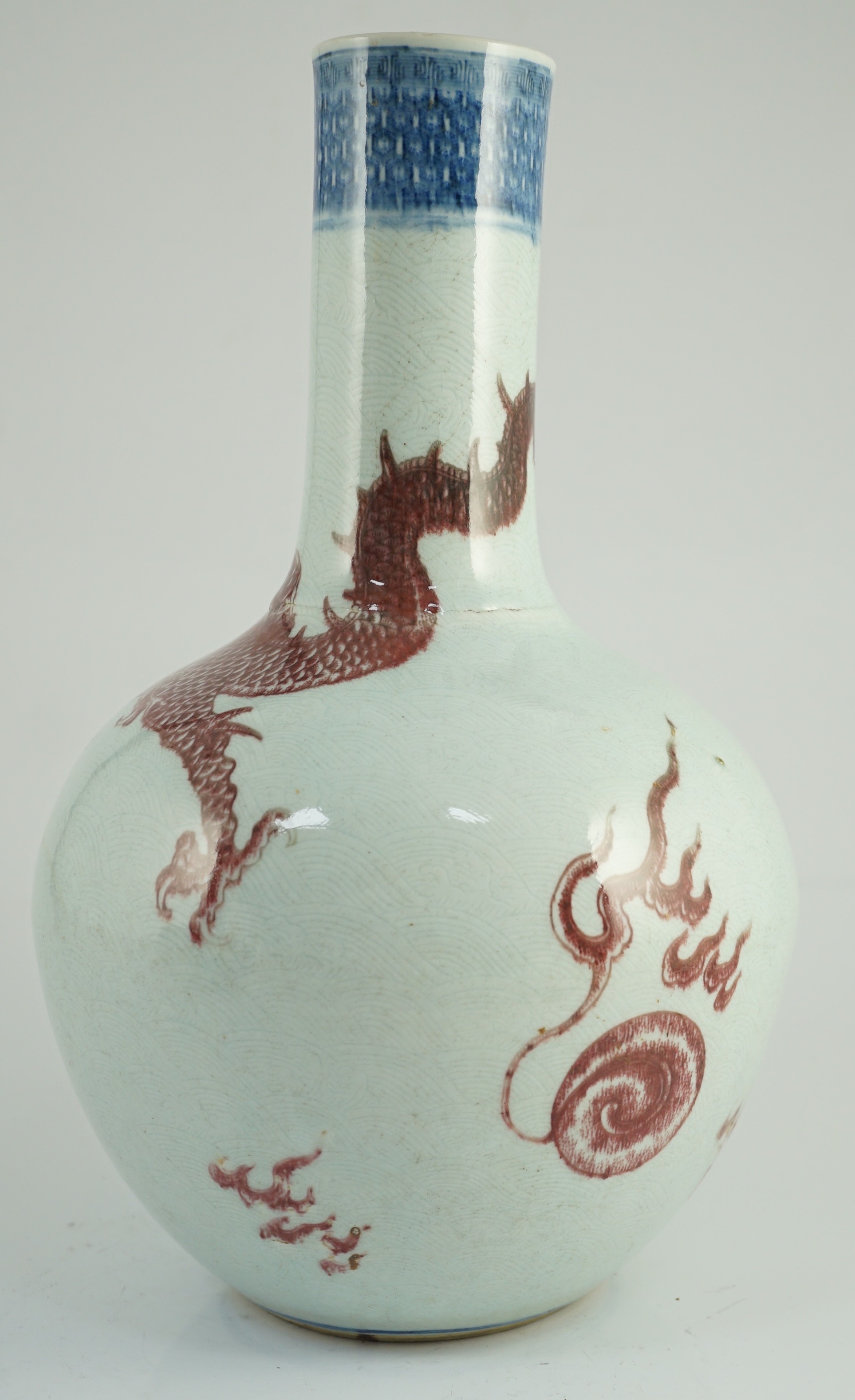 A rare Chinese underglaze blue and copper red 'dragon' vase, tianqiuping, 18th century, 38cm high, firing faults, hairline cracks